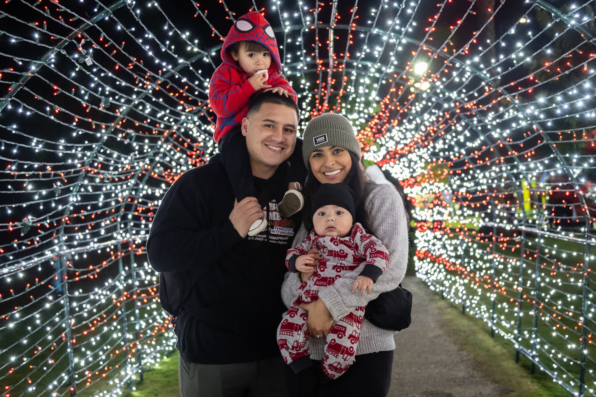Family posing inside the SnowSide Christmas light tunnel