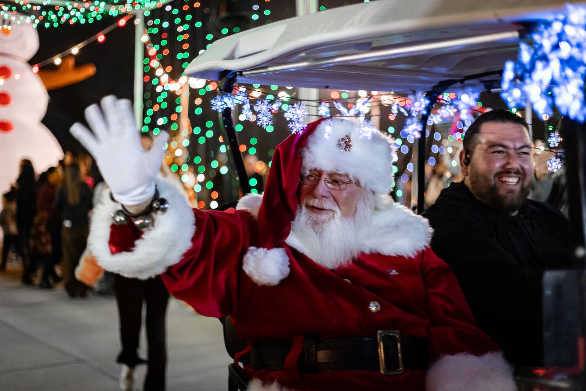 Santa on a decorated golf cart at SnowSide